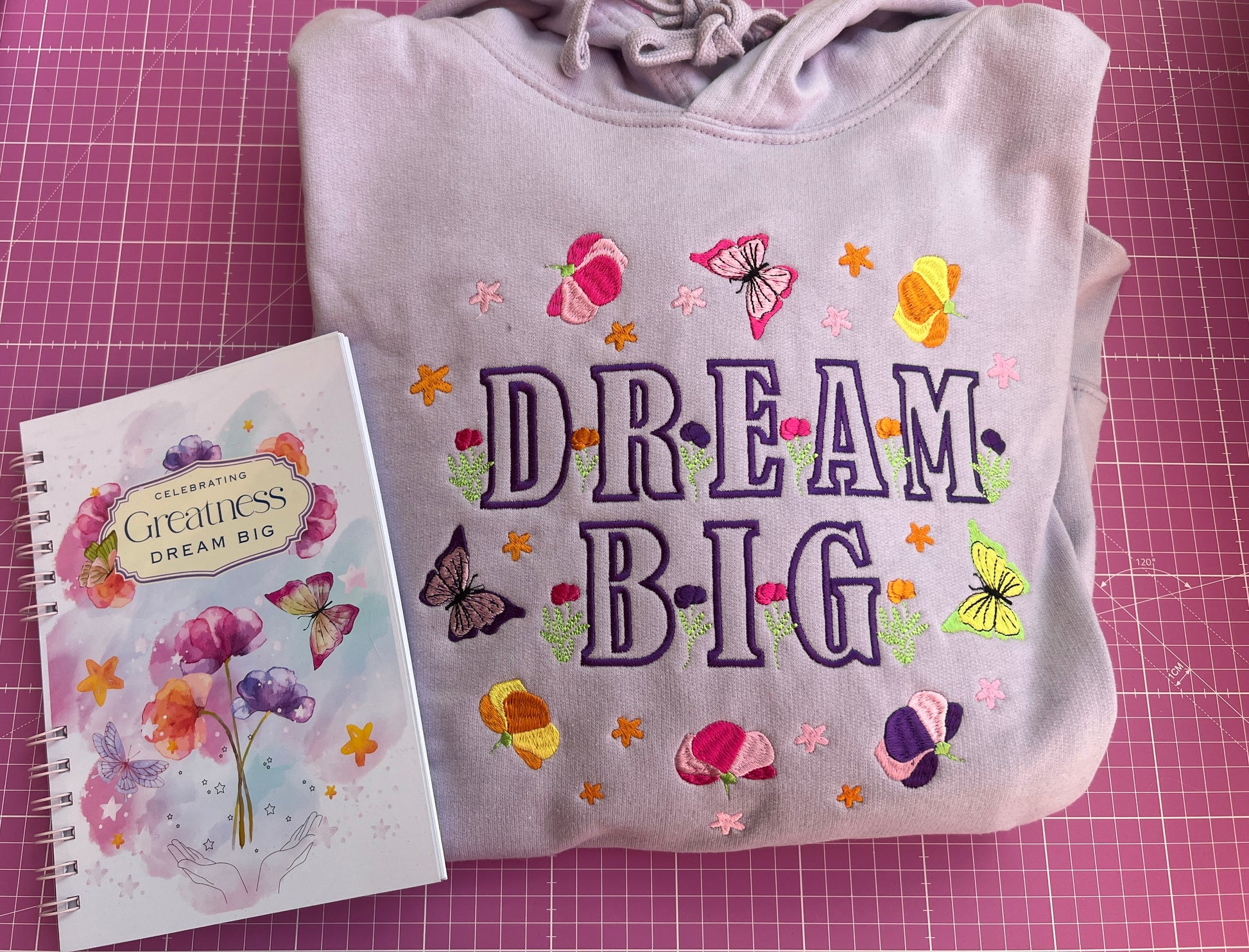 Children's shirt with 'Dream Big' text and colorful designs on a pink grid background