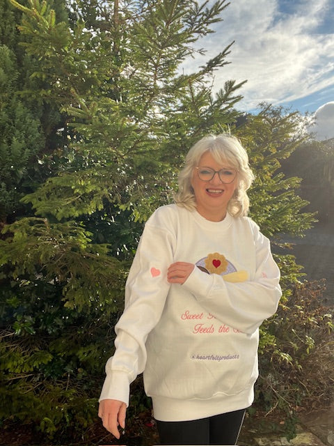 Person wearing a white sweatshirt with a design outdoors